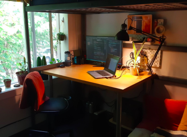 A desk with a laptop and lamp
