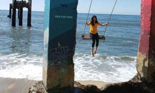 Yasmin on the swings at a beach