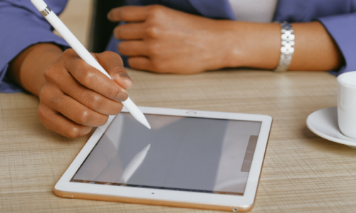 person using apple pen to write on ipad