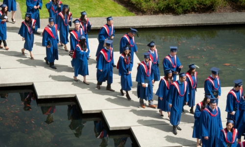 Aerial view of students walking across pond in the Academic Quadrangle during convocation