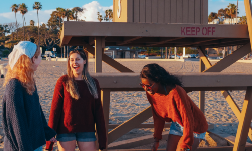 three women laughing at a beach