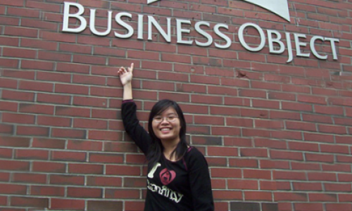 Jeanni standing in front of the business objects sign