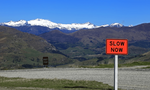 A road sign that says Slow Down