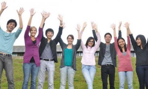 8 studnets standing in a line with their hands in the air celebrating