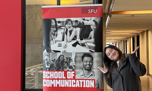 Brianna standing in front of a Communication Banner 