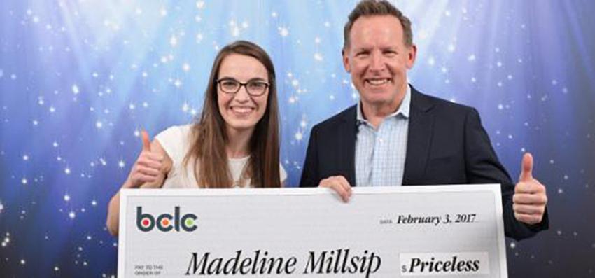 A student and CEO holding a large cheque 