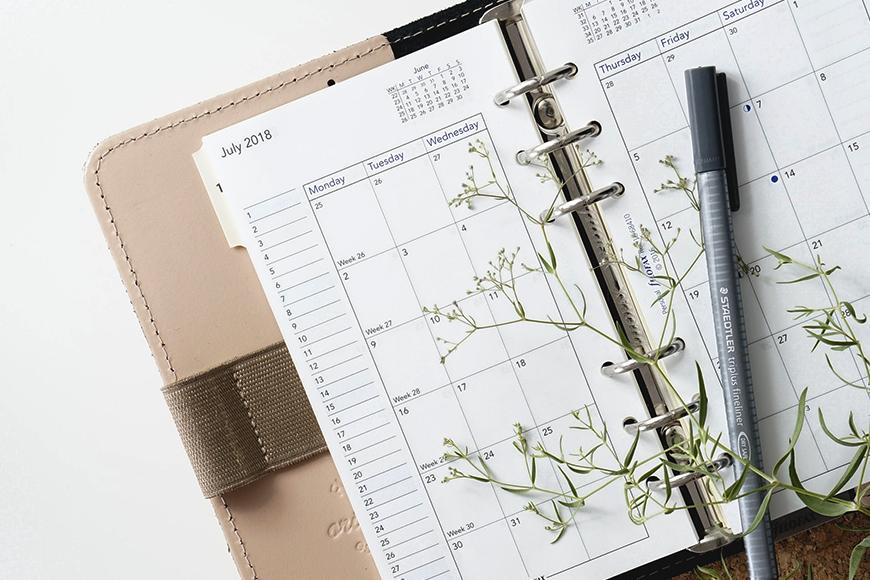 a planner with some wild flowers layout on top