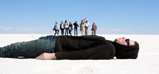 Image of a person lying down with people standing on top