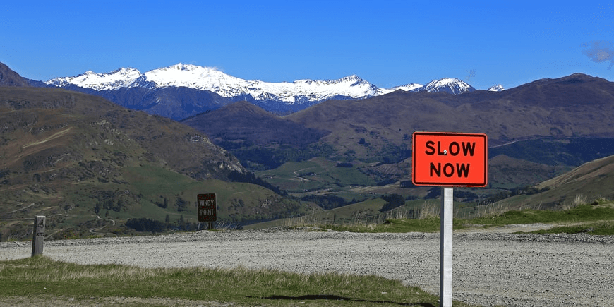 A road sign that says Slow Down