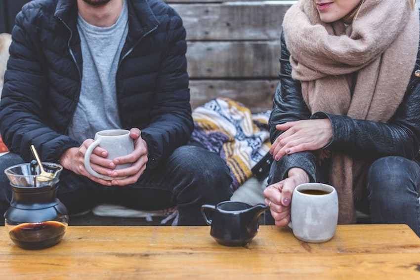 Neck below image of two people have coffee together