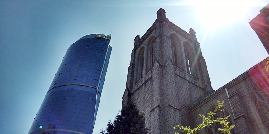 a low angle of a church in downtown Vancouver against the sunny background