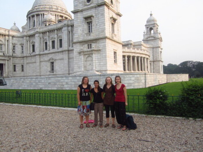 The girls standing in front of a large white marble building