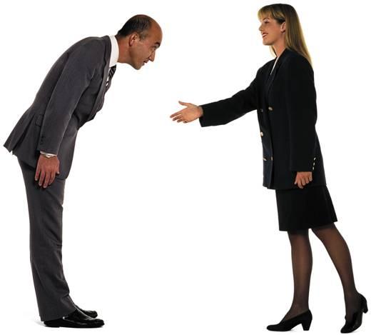 A man bowing while a woman is about to give handshake