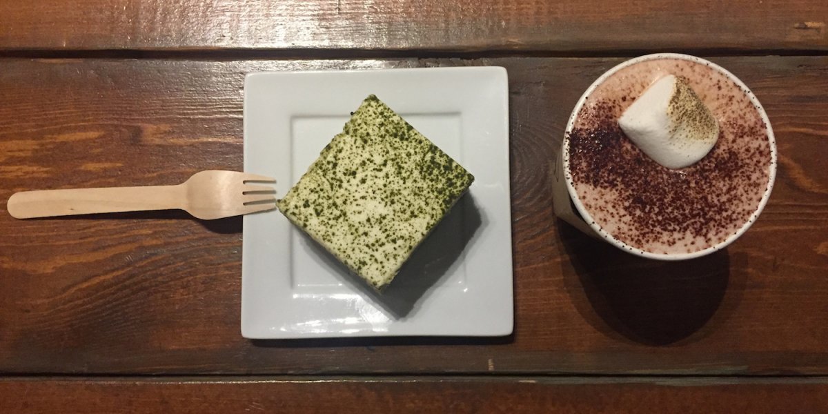 Picture of Shazia's food; a square with green dust on the top beside a cup of coffee from aerial point of view