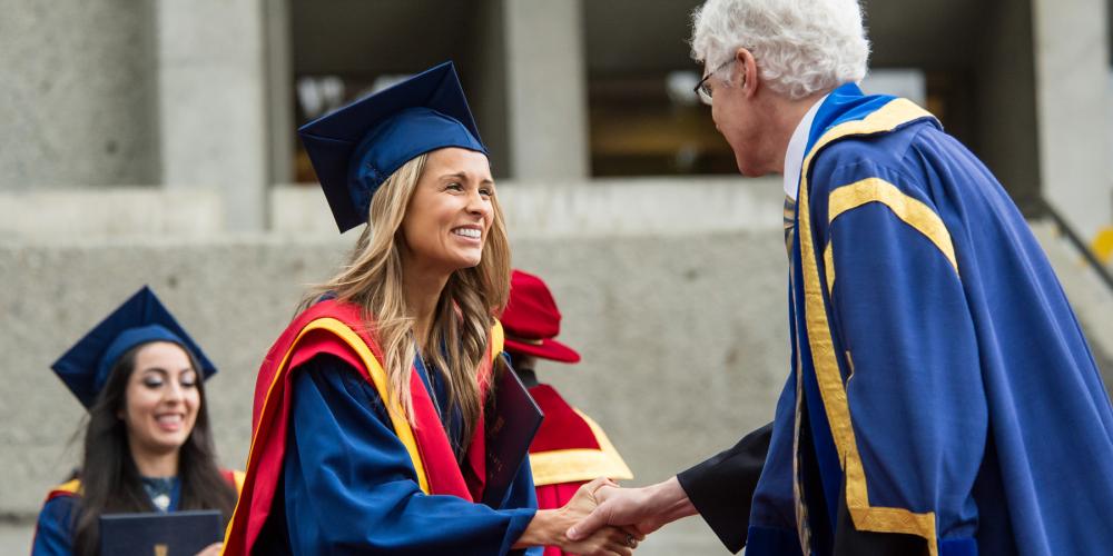 SFU graduate shaking hands with faculty member