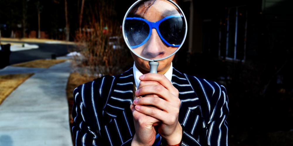 Person holding a magnifying glass to their eye