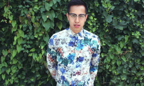 Steven Phan standing in front of lush green background wearing a floral shirt 