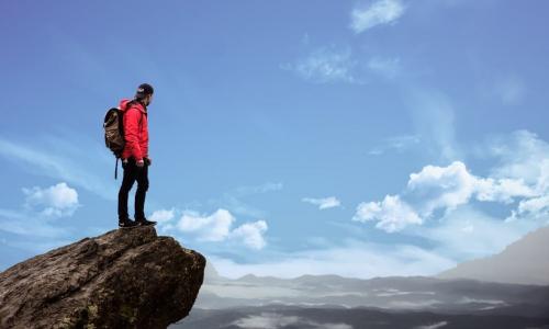 man standing on rock looking at sky