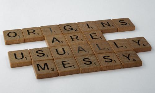 Scrabble Tiles spelling out the phrase "origins are usually messy"