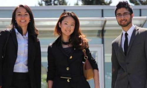 Three students standing in professional attire, side-by-side