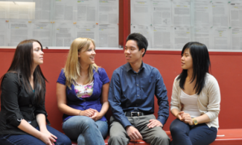Four students chatting with each other while sitting down.