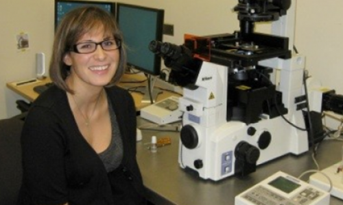 Picture of Jessica beside a microscope