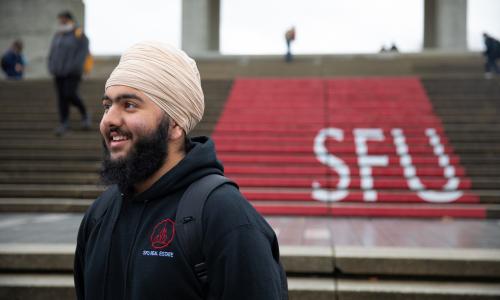 Close up of Mehtaab infront of SFU logo