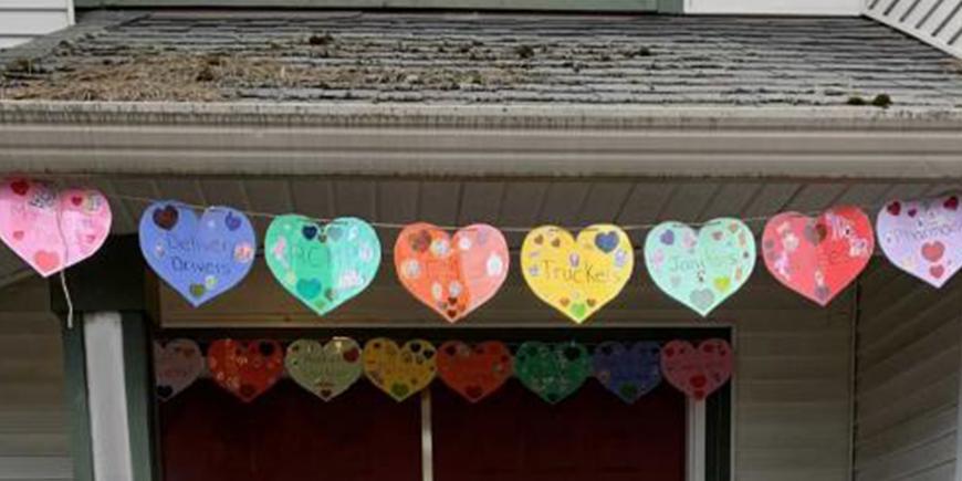 hand-drawn paper cut hearts strung across the roof of a house