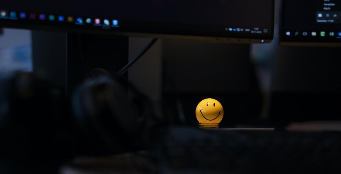 a yellow smiling face figure in a dark room