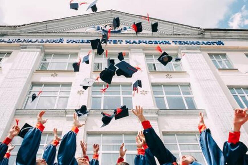 Graduates throwing their graduation caps up in the air