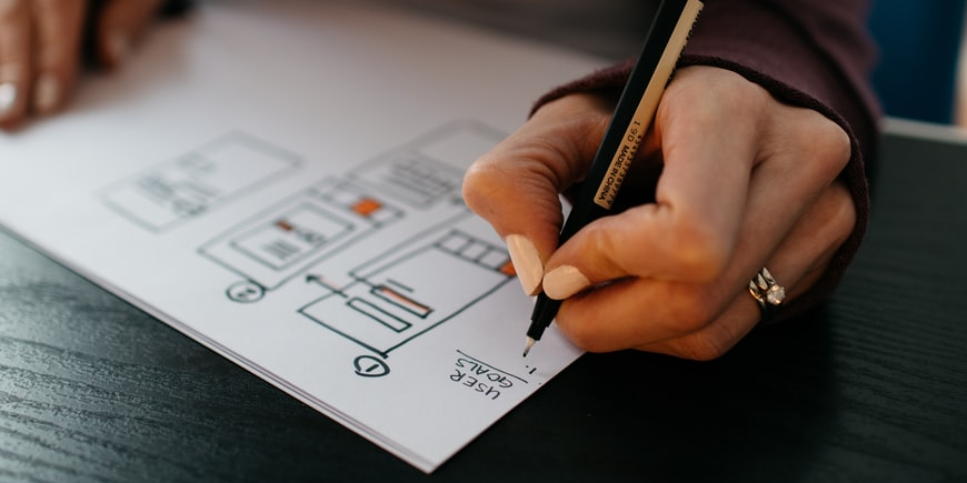 A hand working on a UX wireframe