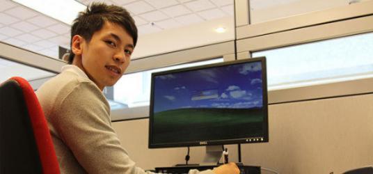 Picture of kenny yang working at a computer