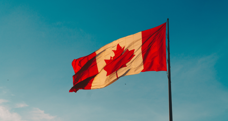 A Canadian flag against the blue sky