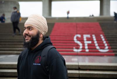 Close up of Mehtaab infront of SFU logo