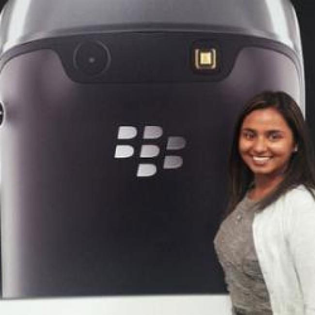 A woman standing in front of a Blackberry poster