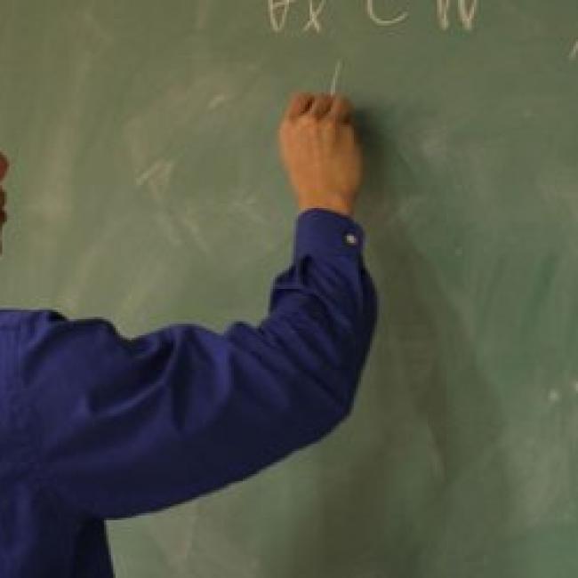 Teacher writing on a chalkboard