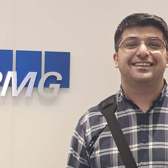 man standing in front of sign that says "KPMG"