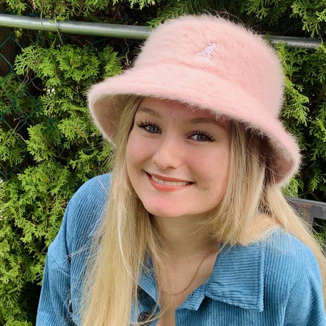 Girl wearing a pink bucket hat smiling at the camera 