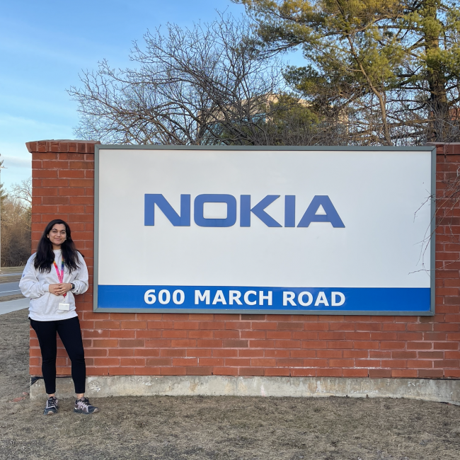 An image of a girl standing next to Nokia's board 