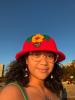 A picture of a woman wearing a strawberry hat.