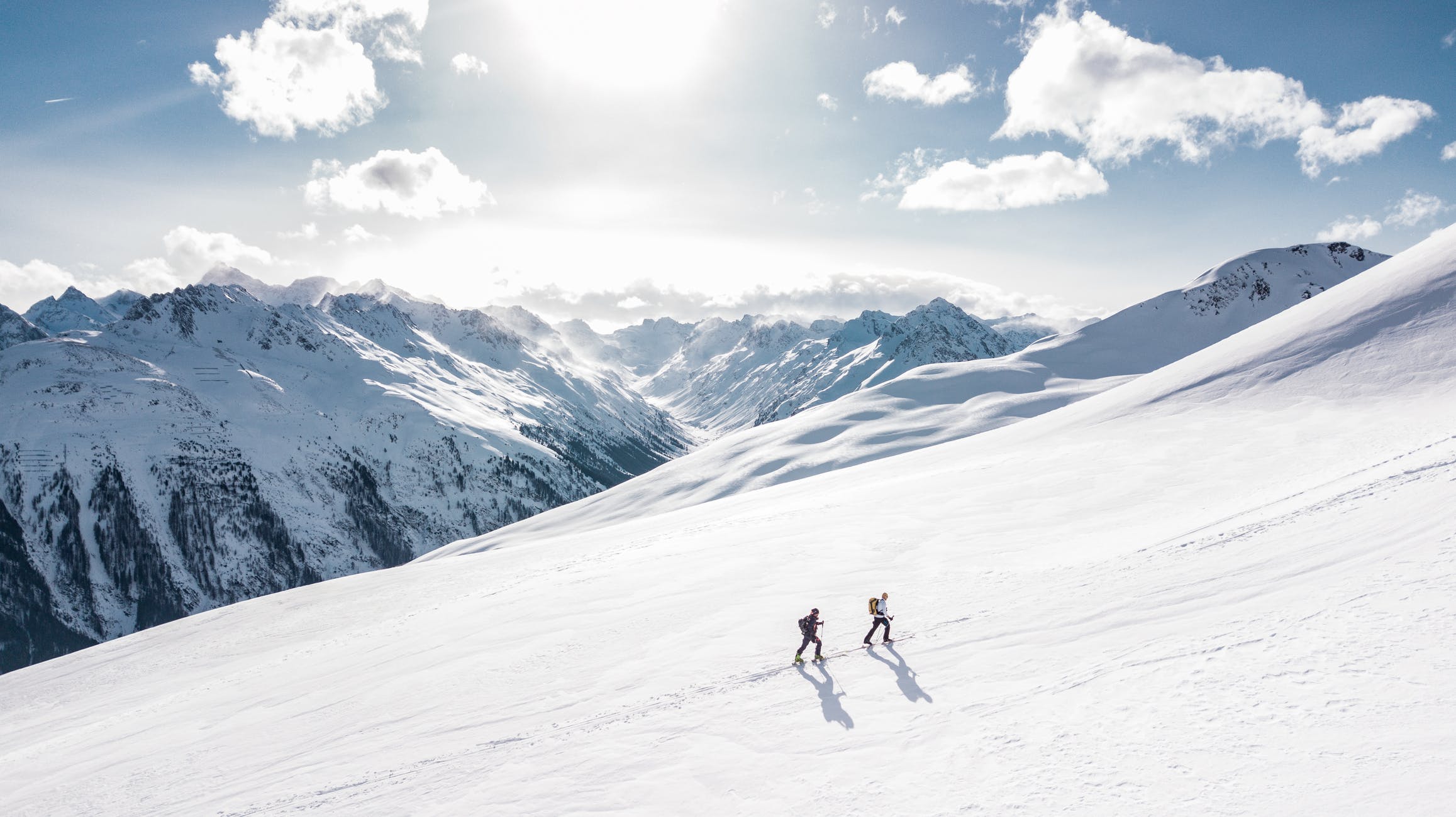 2 people climbing a snowy mountain