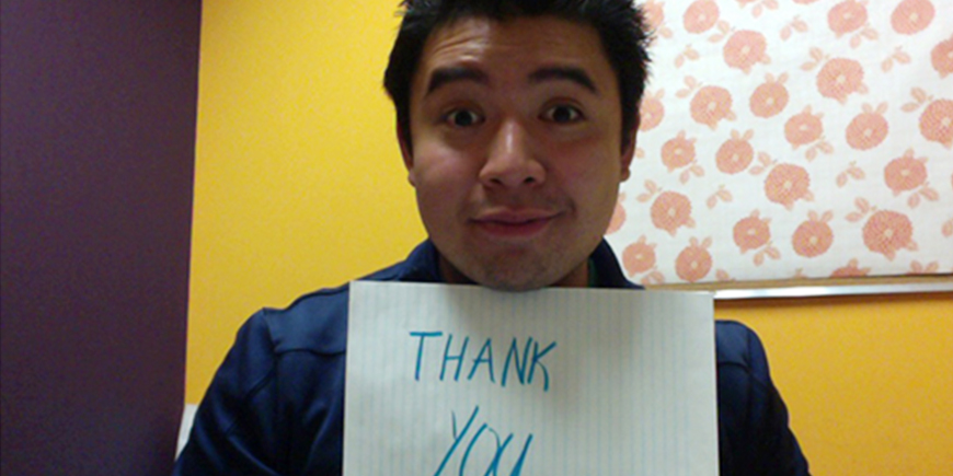 the author holding a "thank you" note