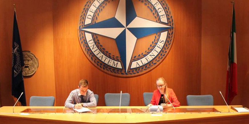 Cornel and another person sitting at the Defense College boardroom