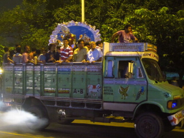 People gathered on a green truck, smiling