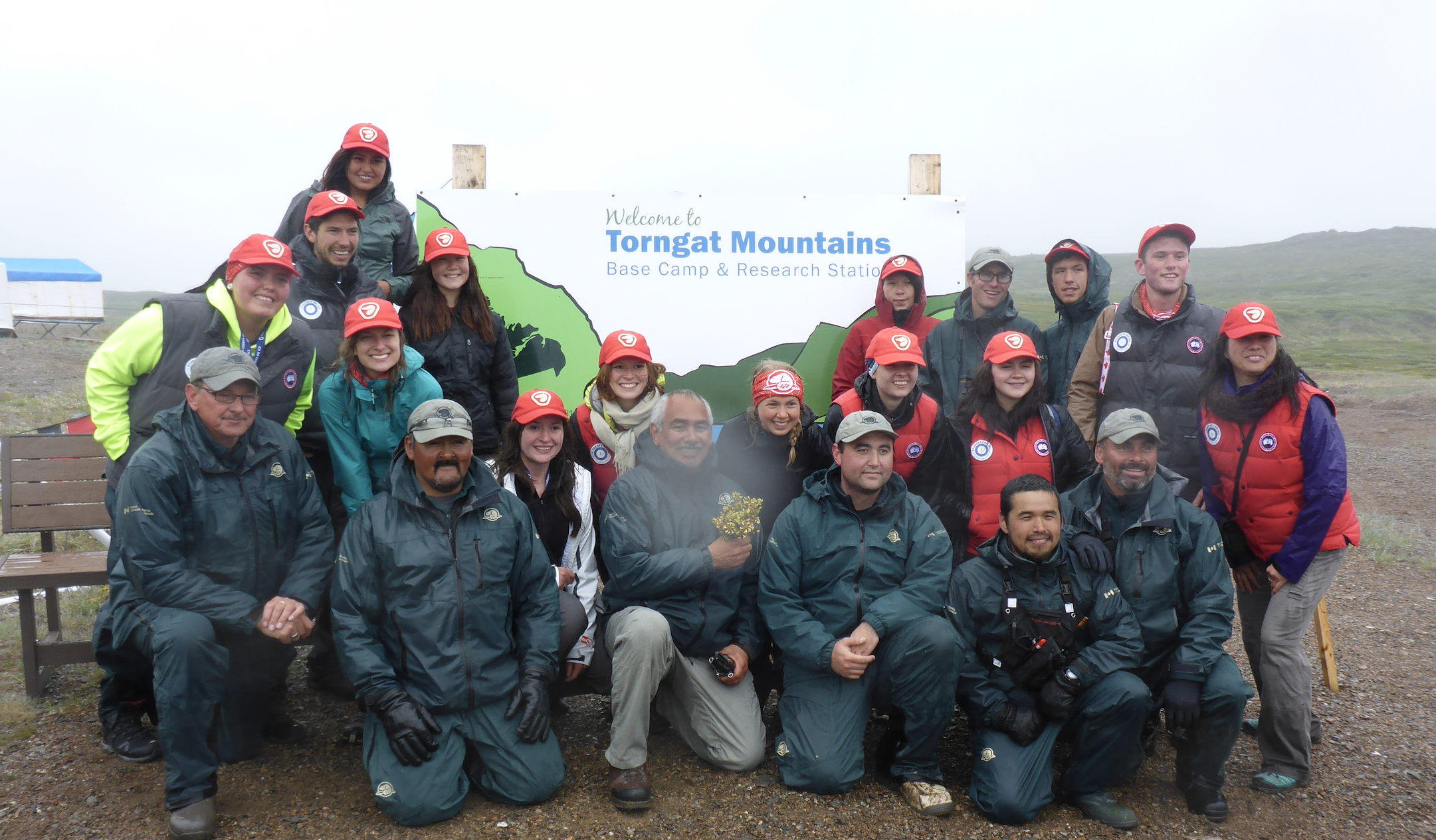 Sarah and her teammates in front of a Welcome to Torngat Mountains sign