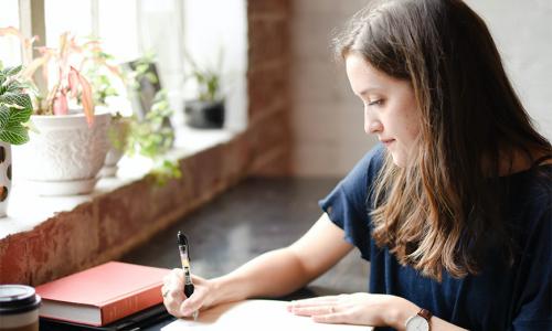 a girl writing in a notebook
