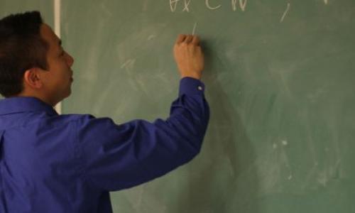 Teacher writing on a chalkboard