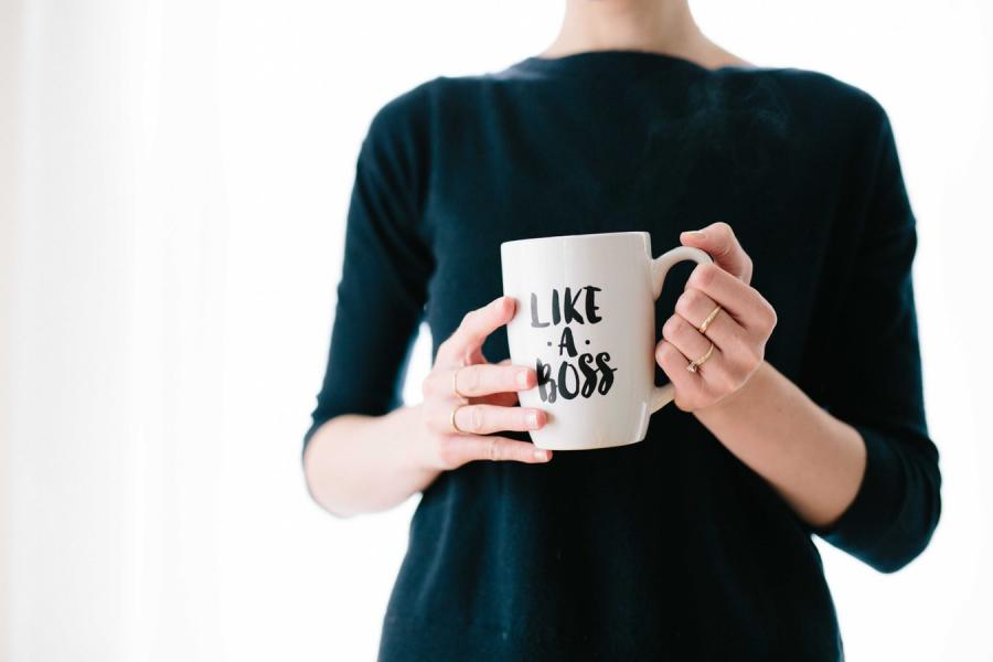 a woman holding a mug that says "like a boss"