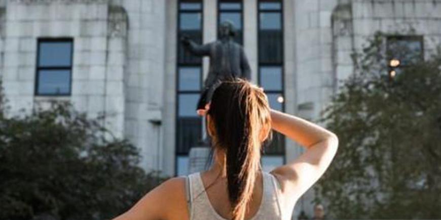 a girl saluting in front of a statue