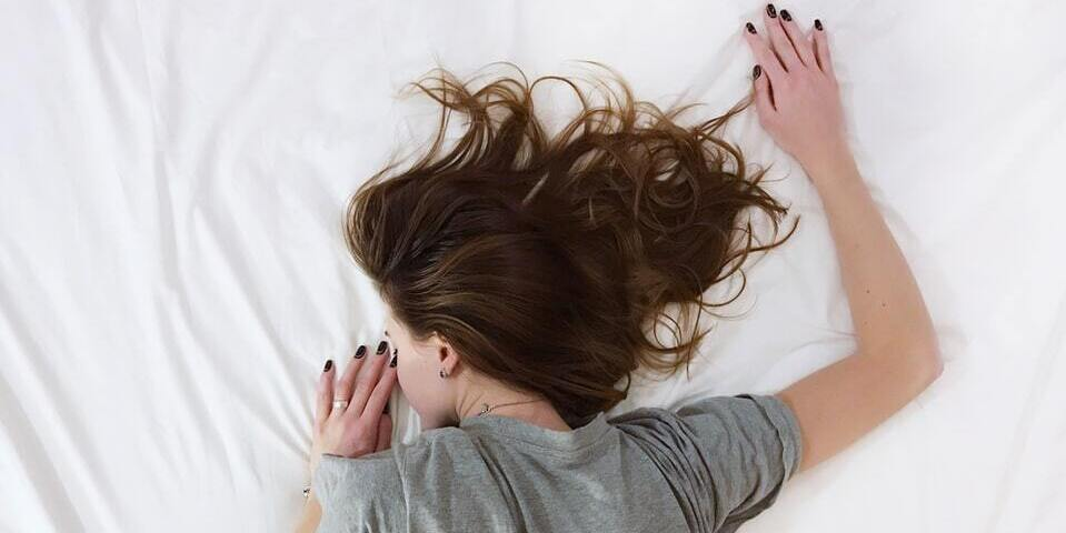 A girl sleeping face-front on a bed